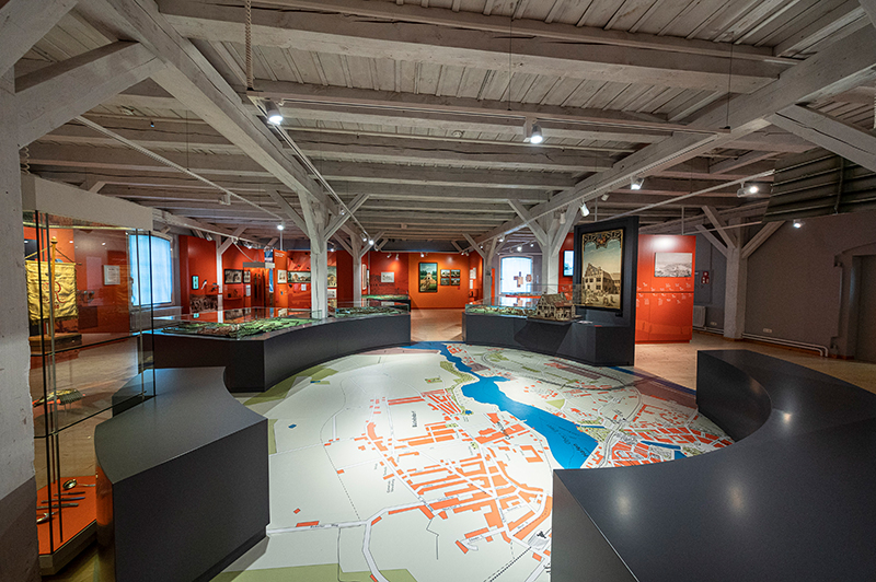 Die Ausstellung des Historischen Museums. Auf dem Boden ist zentral eine Stadtkarte Rendsburgs abgebildet.