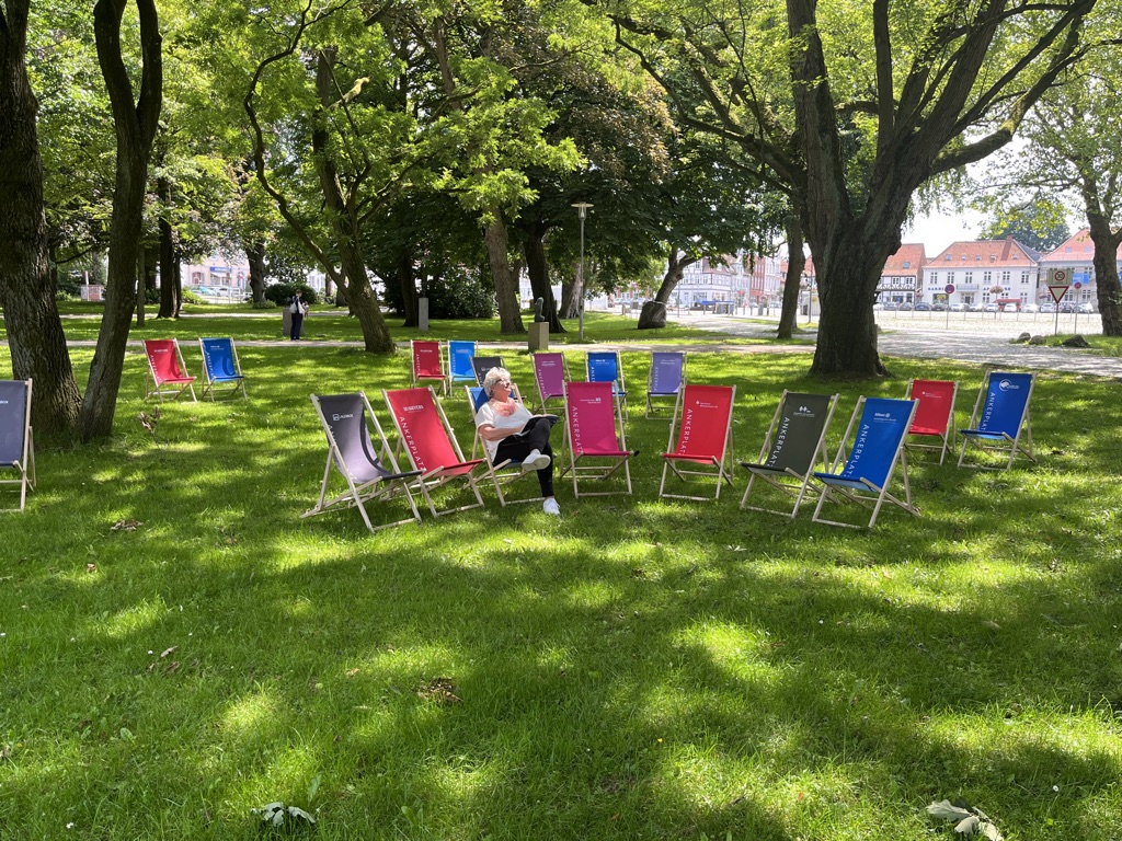 bunte Liegestühle auf einer Wiese im Stadtpark